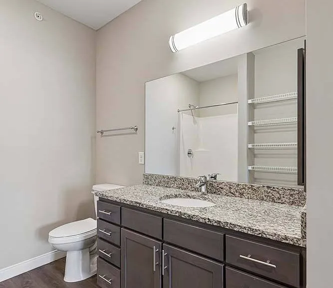 Featuring a sleek granite vanity, generous storage, and clean modern finishes, this bathroom is designed to make every day feel a little more refined.
