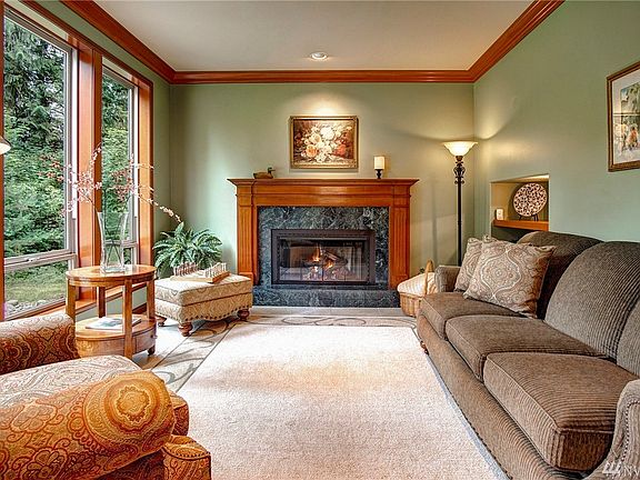 Formal living room with solid cherry wood mantle, remote gas fireplace and tall windows overlooking the private front yard.