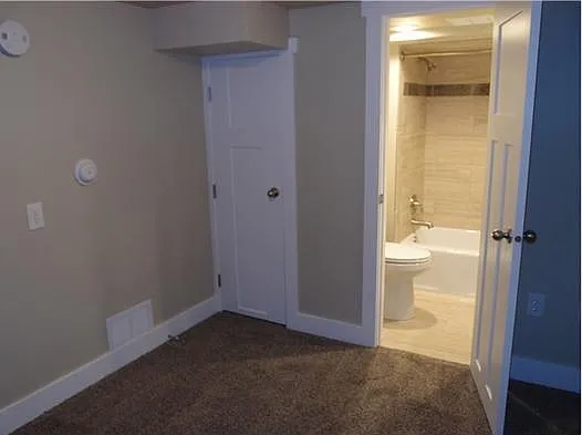 bedroom with closet door and bathroom door