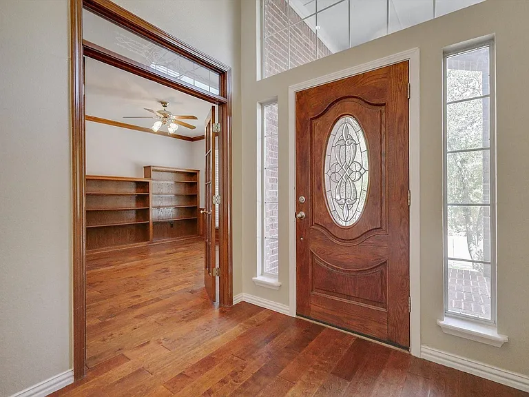 Soaring ceilings, wood flooring and private office with french doors and built-in shelves.