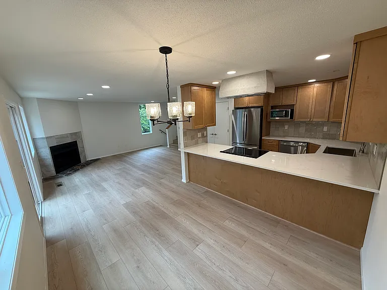 View from dining room showing the breakfast bar (along the quartz countertop edge). Easy eating with room for additional table and seating.