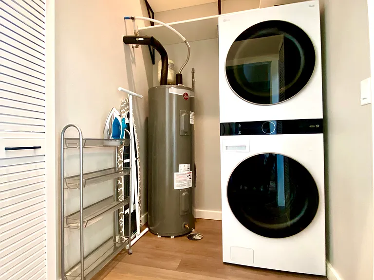 Separate utility room houses full-size wash/dry tower, full-size ironing board and iron, fire extinguisher and fire blanket, and lots of large shelves for storage above.