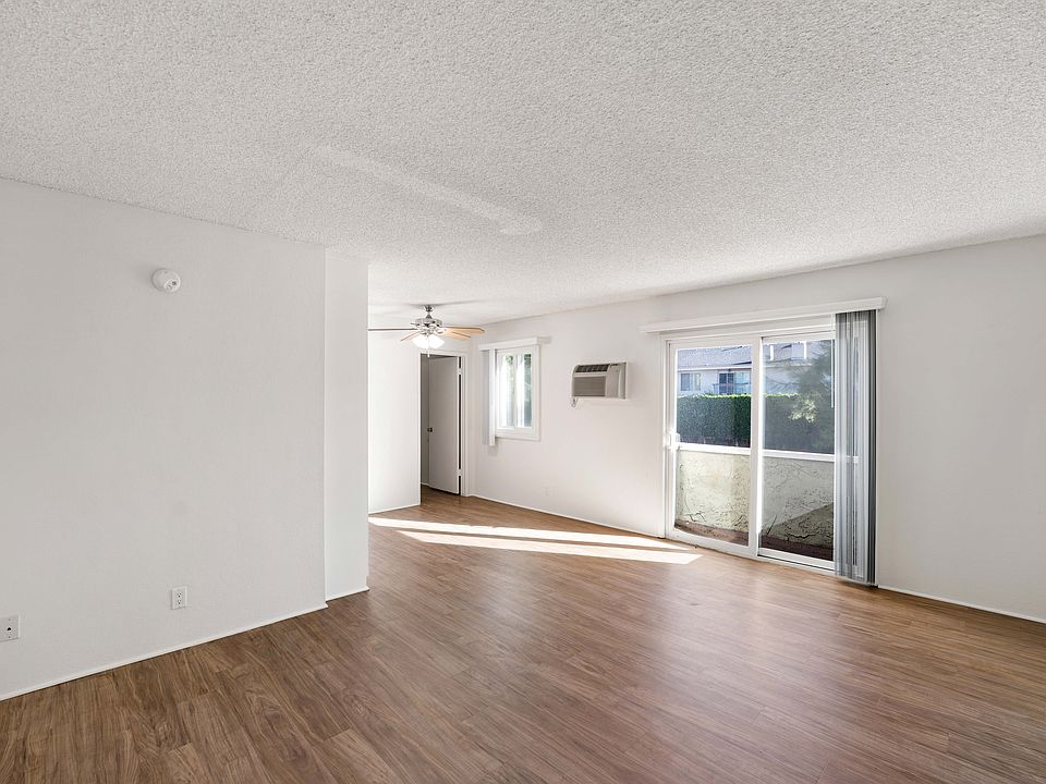 Sun-filled living space with wood-style floors and a private patio at Excelsior Apartments in Studio City.