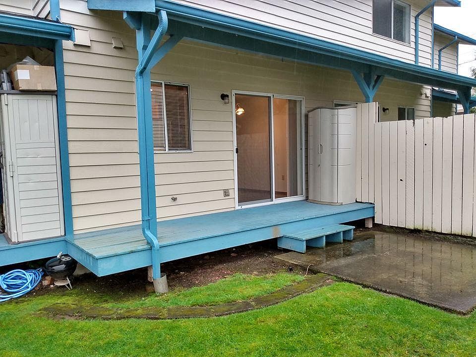 Small back deck off the kitchen, with small locking cabinet on the deck, grassy common yard.