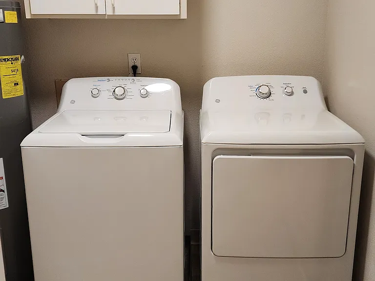 Private laundry room with full-sized washer and dryer.