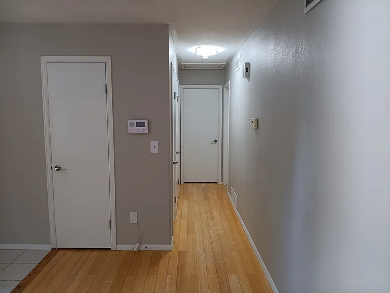 Hallway leading to 2 bedrooms and bathroom, and access to basement
