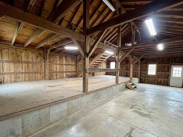 Expansive lower level of the barn featuring rustic timber framing.