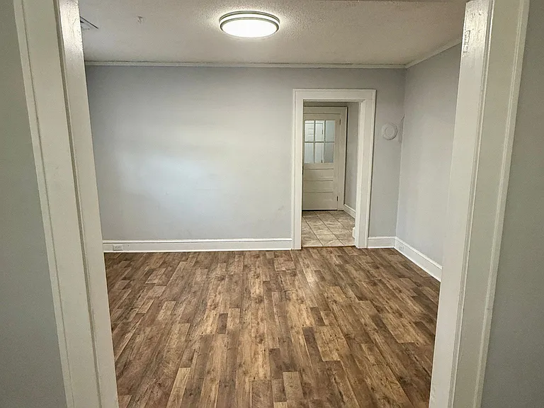 Living space looking into the dining area and kitchen entrance.