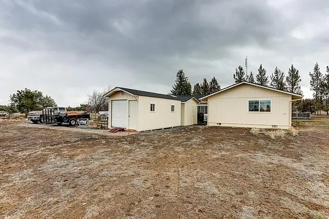 View of backside of house and 10X20 storage shed and 10X12 storage shed.