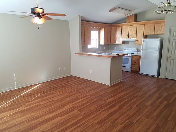 Living room and open kitchen with new flooring and paint.