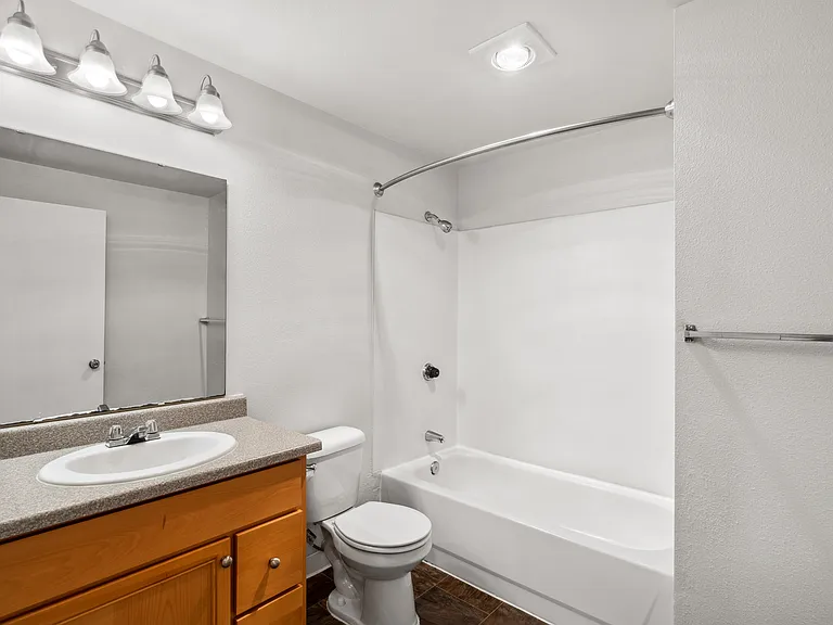 Modern bathroom with vanity storage and full shower-tub setup.