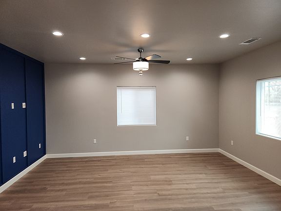 Living room with recessed lighting and ceiling fan.