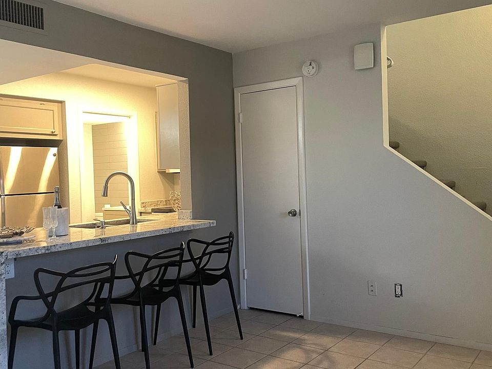Stairway on the right, coat closet underneath, kitchen with waterfall effect on the left.