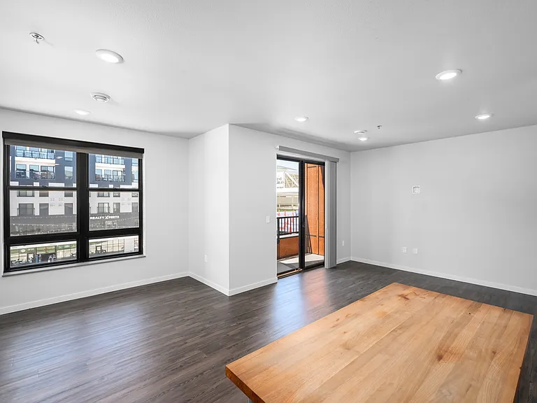 Bright modern living room with hardwood floors, large windows, and a balcony for outdoor enjoyment. Bright modern living room with hardwood floors, large windows, and a balcony for outdoor enjoyment.