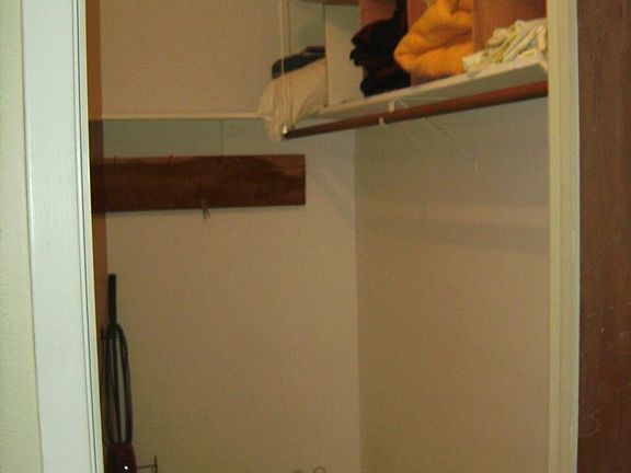 walk-in closet stocked w extra linens, blankets, iron board.