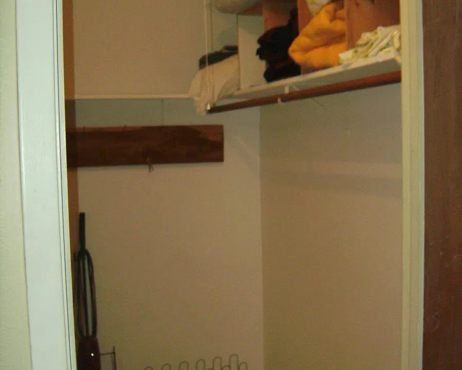 walk-in closet stocked w extra linens, blankets, iron board.