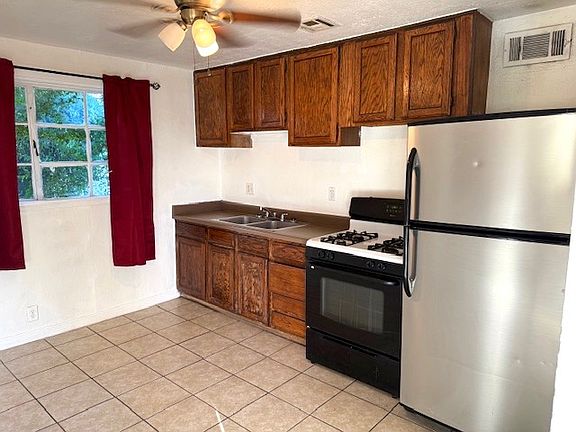 Spacial country kitchen with gas stove and large refrigerator