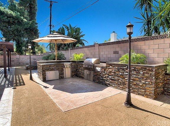 The awesome entertainers backyard features custom BBQ area with stacked stone, cement counter tops, 