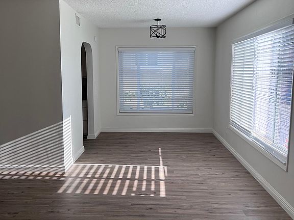 Living room with new floor, new paint, new dining room light , new blinds