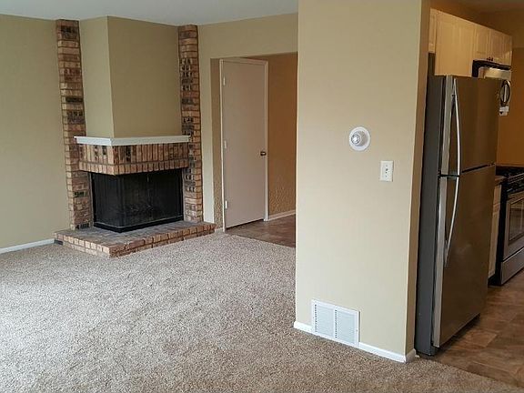 Living room with wood burning fireplace (flooring just replaced - no longer carpeted)