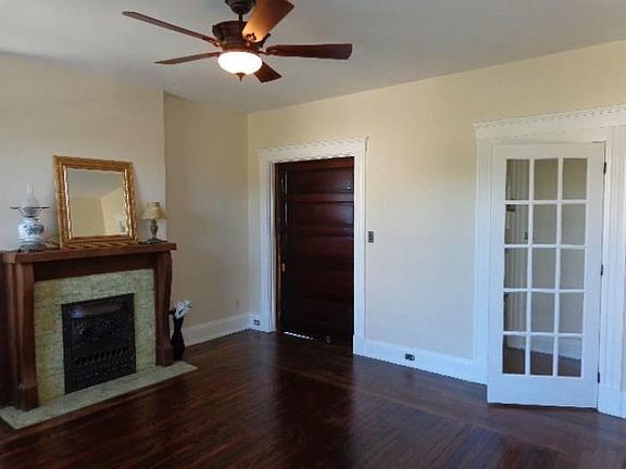 Living room with working pocket door and decorative fireplace.