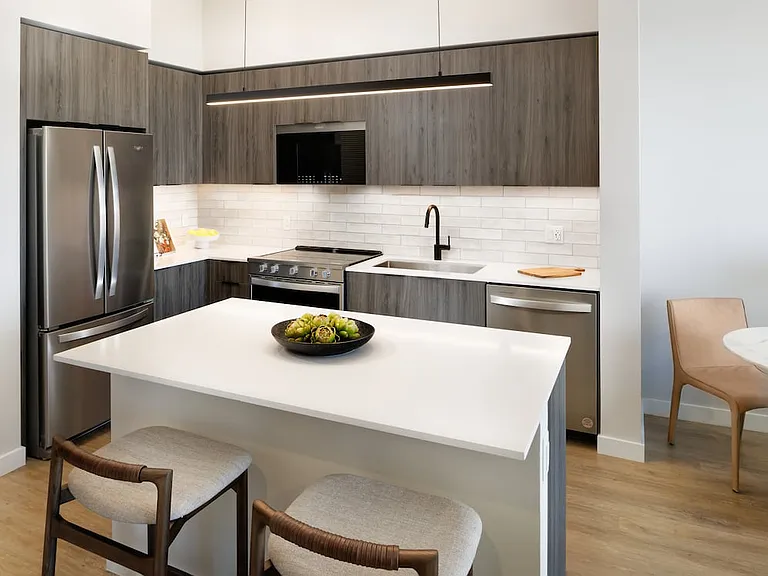 Upgrade Collection II kitchen with espresso cabinetry, white tile backsplash, white quartz countertop, and hard-surface vinyl plank flooring