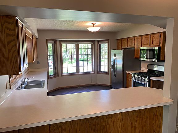 Light and bright Kitchen with stainless steel appliances and hardwood floors. The stove is gas.