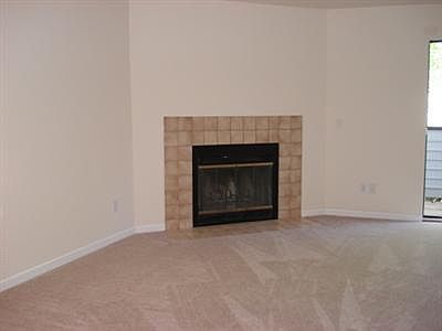 Large living room with cozy wood burning fireplace and lots of natural light.