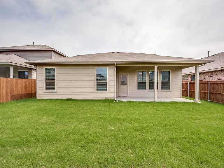 Back of house with a yard and a patio