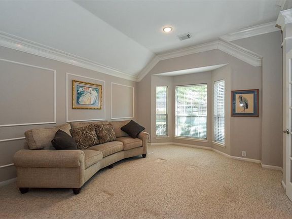 French doors welcome you to the formal living room with a tray ceiling, recessed lighting and plenty of natural light beaming through the front bay window.