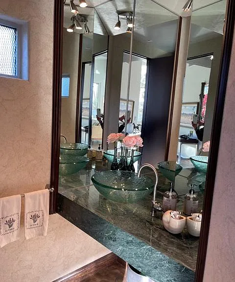 Etched glass floating powder bath sink on solid green marble