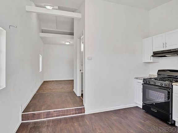 Hardwood leading into bathroom & in bathroom. Carpet in bedroom.