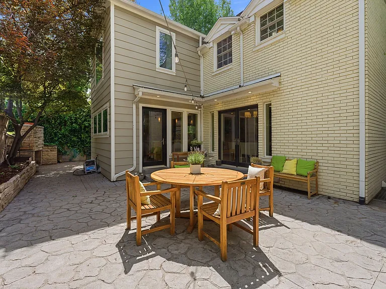 Private back patio with mature trees and entrances from both dining room and kitchen.