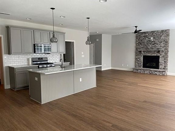 Open kitchen, dining and living area with a beautiful stone fireplace that uses gas so no need for firewood