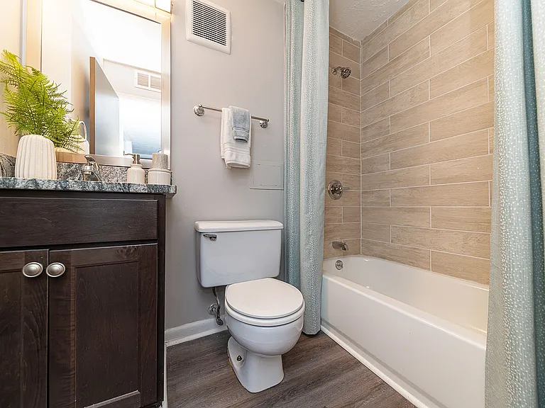 Bright bathroom with granite counters and bathtub