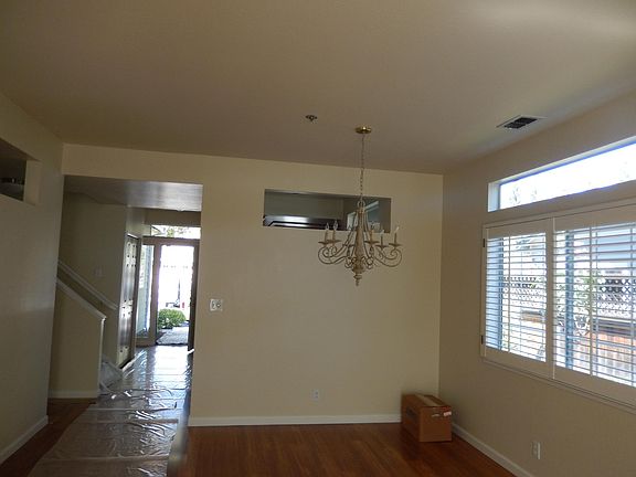 Diningroom/livingroom area with hardwood flooring and plantation shutters. Gas fireplace in livingroom.