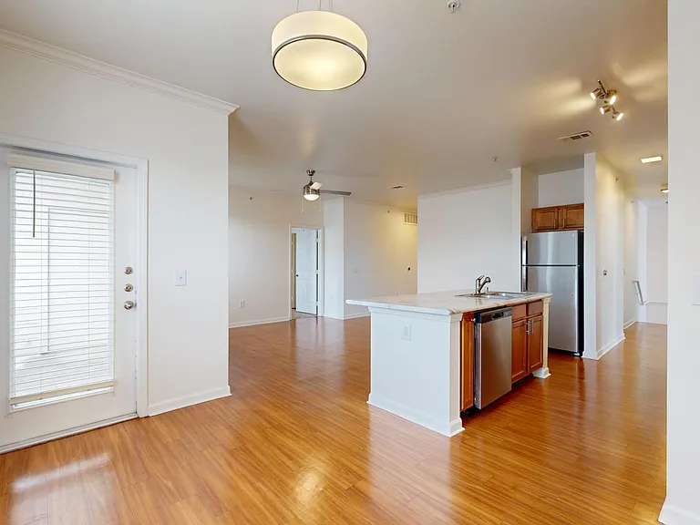 Apartment Kitchen with Stainless Steel Appliances, Dining and Living Room with Wood Style Flooring and Patio/Balcony.