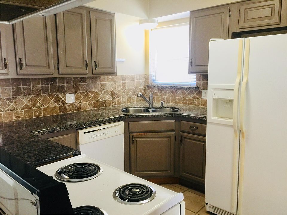 Granite countertop kitchen with lots of storage area. Fridge