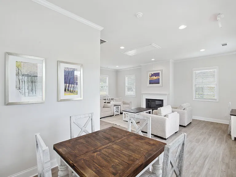 Upscale clubhouse lounge with a dining table and fireplace centerpiece.