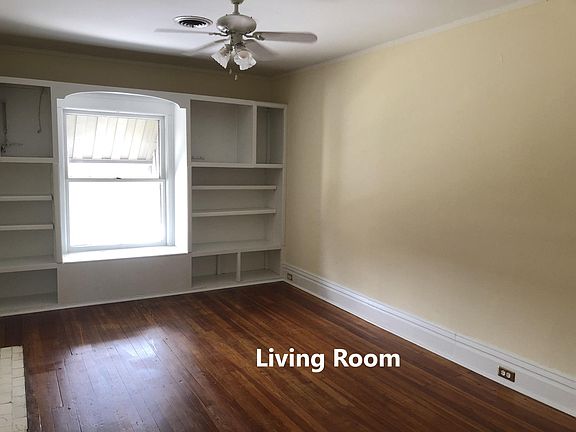 Living Room with newly refinished hardwood floors, built in book case, ceiling fan