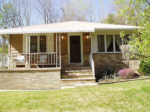 Front of home, taken in front of pine trees which provide privacy