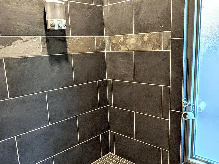 Beautiful walk-in guest shower with pre-installed shampoo/body wash dispenser.