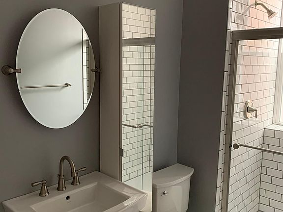 Bathroom with shower and mirrored storage