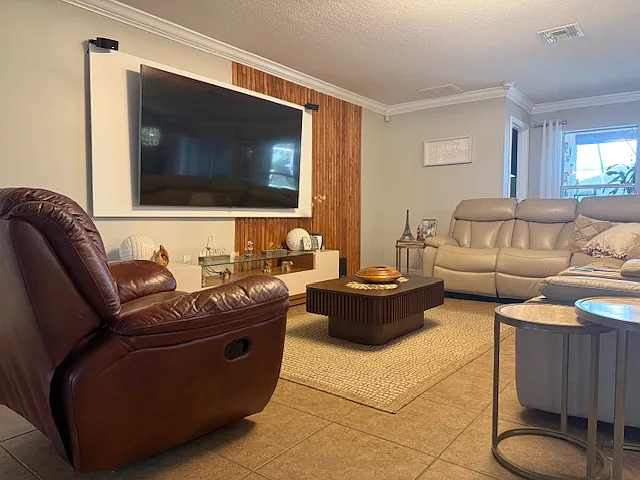 Inviting living room with modern accent wall and large entertainment space.