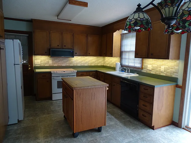 Open kitchen with moveable island. Undercounter lighting. Ample natural light.