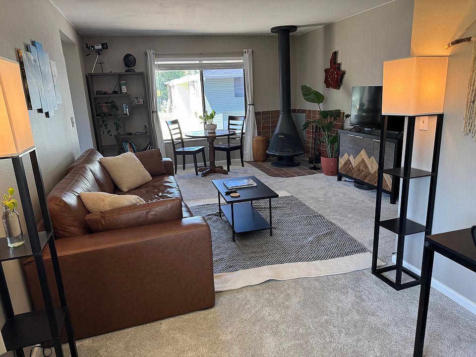 Living room with mid century modern fireplace, couch, credenza, coffee table, and shelving unit.