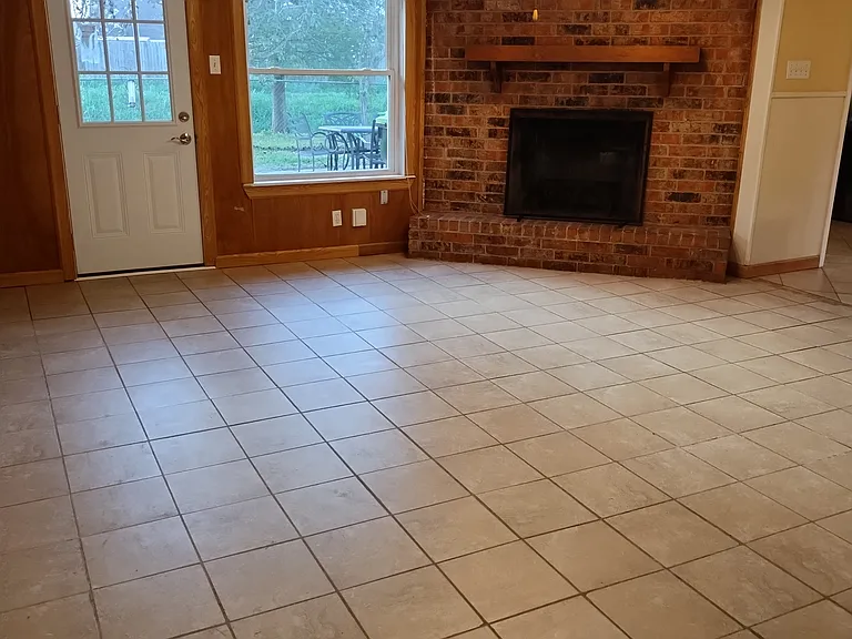 From Entryway looking into Den with back door, fireplace, and kitchen in picture.