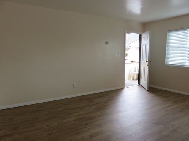 Large, living room area with manufactured wood floor.