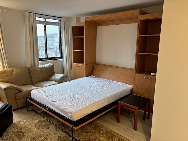 Queen murphy bed opened and shelving unit.
