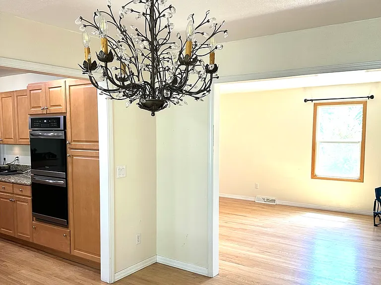 At back wall of dining room, facing living room, with kitchen on the left